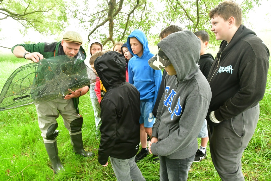 Žáci ZŠ Sokoleč si prohlížejí úlovek.