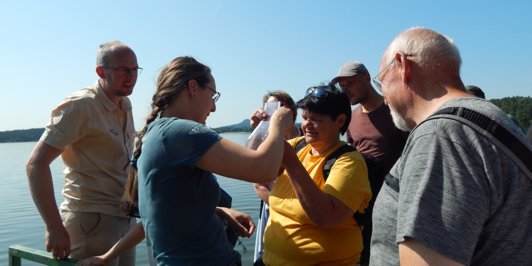 Účastníci exkurze zblízka pozorují drobné živočichy, kteří pomáhají udržovat kvalitu vody.